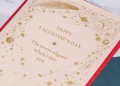 Valentine's Day card with red envelope. A heart surrounded by stars, planets and comets. The text reads Happy Valentine's Day. The stars aligned when I met you.