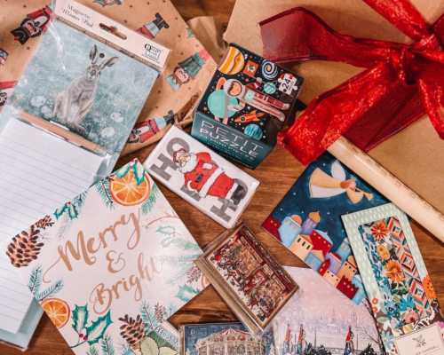A selection of Christmas cards and gifts laid on a table.