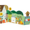 Carousel style birthday card with an illustration of a garden shed which opens to reveal a garden with flowers, birds, bees and more. Text on the shed roof reads 'happy birthday'.