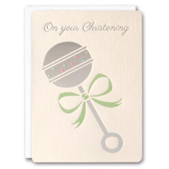 Christening card with silver text at the top reading 'On your Christening'. Below the text is a baby's rattle with a round silver circle at the top which is decorated with coloured dots. The rattle has a pale green bow tied round the middle.