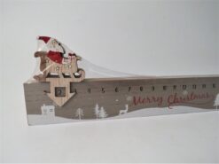 Image of a wooden advent ruler. The numbers 1 to 24 run along the ruler with a snowy festive scene below with houses, trees and wildlife. Santa in his sleigh sits on top of the ruler with an arrow pointing down over the numbers. Move Santa along the ruler