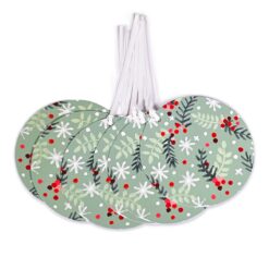 6 giant tags by Deva Designs. Round tags with white ribbons with an image of green and black festive foliage and red berries. Decorated with white snowflakes.