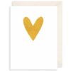 A white card with a gold heart on the front.