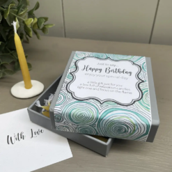 12 mini beeswax candles and a white ceramic candle holder in a presentation box. Text on front of box reads Just to say Happy Birthday enjoy your special day. a little gift just for you a box full of relaxation candles light on and focus on the flame.