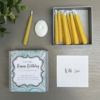 12 mini beeswax candles and a white ceramic candle holder in a presentation box. Text on front of box reads Just to say Happy Birthday enjoy your special day. a little gift just for you a box full of relaxation candles light on and focus on the flame.