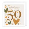 Golden wedding anniversary card with a large 50 in the centre and the text Happy Golden Anniversary at the top. The card is decorated with gold, black, white and pink hearts.