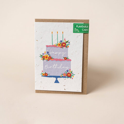 Plantable Happy Birthday card featuring an illustration of a two tier birthday cake decorated with candles and bright, colourful flowers.