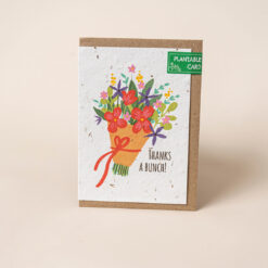 Plantable card with a bouquet of flowers wrapped in brown paper and tied with a red bow. Text reads Thanks a Bunch!