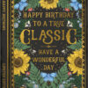 Birthday card in the shape of a book. Text on the front reads Happy Birthday to a True Classic - Have a Wonderful Day. The card is decorated with sunflowers, green foliage, butterflies, bees and ladybirds.