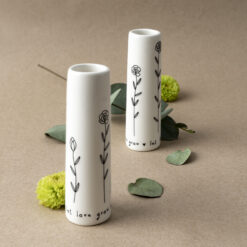 Two mini white vases with delicate floral design in black.
