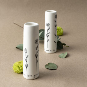 Two mini white vases with delicate floral design in black.