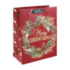 Large red Christmas gift bag with wreath design and the text Merry Christmas. The bag has green handles and a red gift tag.