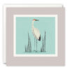 A Pale purple square card with an illustration of a crane standing among grass reeds.