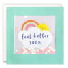 Pale blue card with a square window which contains paper circle confetti. Illustration shows a cloud with the text 'feel better soon'. Above the cloud is a rainbow and a smiley sun.