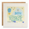 White card with a confetti filled window on the front. The illustration is of a hot air balloon in the sky with silver stars and a large cloud. Text reads Bon Voyage.