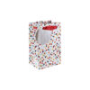 Medium white gift bag decorated with colourful spots. Red handles and a circular, silver gift tag attached.