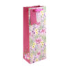 Pink bottle bag with colourful floral pattern. Pink handle and gift tag.