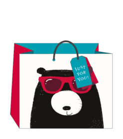 Large white gift bag with red sides. The bag has an illustration of a black bear with white nose wearing a pair of red glasses. The bag has a gift tag attached.