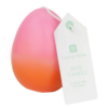 An egg shaped candle which is pink at the top and orange at the bottom in an ombre effect.