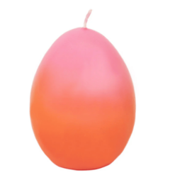 An egg shaped candle in an ombre pink and orange effect. Pink at the top and orange at the bottom.