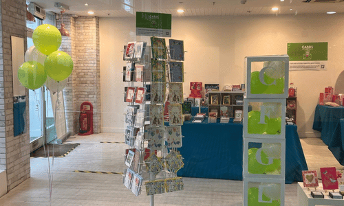 Photograph of a Cards for Good Causes shop featuring a card spinner, gifts and gift wrap.