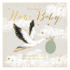 A new baby card with a pastel sky background. An illustration of a stork carrying a grey bag with white spots. Gold text reads 'Beautiful new baby. Welcome to the world little one'. Gold hearts and dots decorate the card.