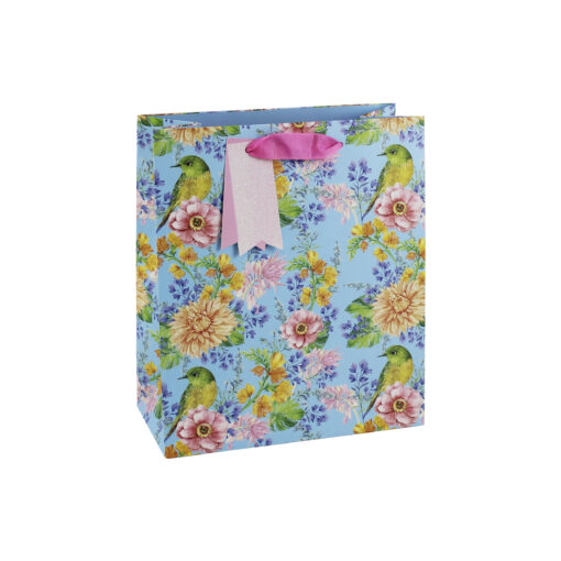 A blue gift bag with a colourful floral pattern and birds sitting on some of the flowers. The bag has pink handles and gift tags attached.