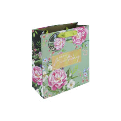 Medium sized gift bag with a pale green background and pink flowers. A gold rectangle in the centre has the text 'Happy birthday'. The bag has green handles and a round floral gift tag attached.