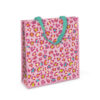Small woven gift bag. The bag is pink with a leopard print pattern and blue handles.