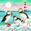 Christmas card with an image of three puffins standing on snow in front of a lighthouse