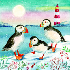 Christmas card with an image of three puffins standing on snow in front of a lighthouse
