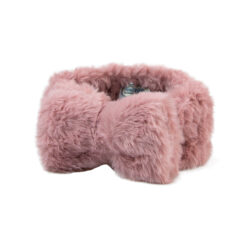 A pink soft fluffy make up headband with a bow detail on top.