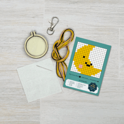 Contents of this product including embroidery hoop, keyring, fabric, needle, thread, and crescent moon pattern