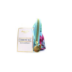 A blue cosmetic bag with botanical pattern, gold zip and round gold tag on the zip.