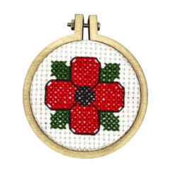 Close up of the finished mini cross stitch poppy in embroidery hoop