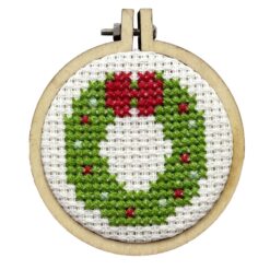 Close up of the finished mini cross stitch wreath in embroidery hoop
