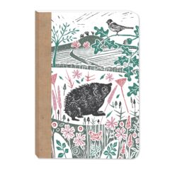 Front cover of this notebook featuring a countryside illustration including a hedgehog among wildflowers, with a bird on a branch above rolling fields and distant trees.