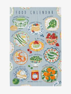 A blue and white striped tea towel with text at the top reading 'Food Calendar'. The towel has illustrations of different seasonal foods, one for each month of the year.