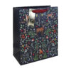 A navy Christmas gift bag with woodland pattern featuring trees, foliage and woodland animals. The bag has red handles and a gold tag.