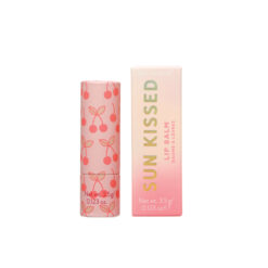 A pink lip balm stick with red cherry pattern next to the box.