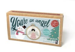 Festive cross stitch mini kit box featuring a snowman and Christmas tree on the front, and angel design in a small embroidery hoop, with text reading “You’re an angel” and “Keyring included.”