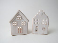 A white, ceramic tea light holder in the shape of a house.