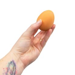 A hand holds a bouncy egg toy.