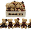 A crate of cuddly soft bears wearing tartan outfits and with hanging loops.