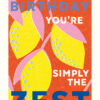 Birthday card featuring a bright, colourful illustration of lemons against an orange background. Large text reads 'Happy Birthday You're Simply The Zest'