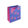 A blue gift bag decorated with pink flamingos, colourful polka dots, striped side panels, and purple ribbon handles.