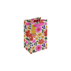 A small gift bag with a colourful floral pattern, pink ribbon handles, and a yellow striped tag.