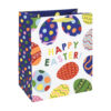 A white and blue gift bag with colourful Easter egg pattern and large text reading Happy Easter.