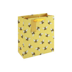 A yellow gift bag with an all‑over bee pattern, finished with yellow ribbon handles and a matching tag.