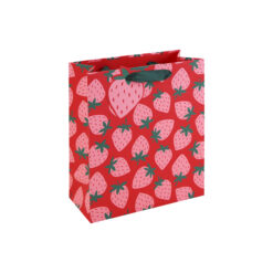 A medium gift bag with a bright red background, covered in pink strawberries with green leaves and finished with green ribbon handles.